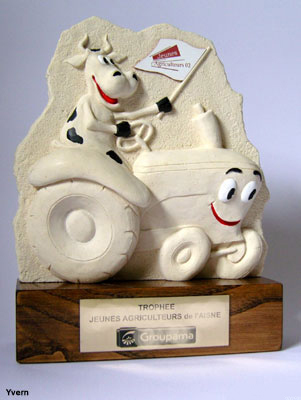 Troph&eacute;e pr&eacute;sentant en bas relief une vache mont&eacute;e sur un tracteur et tent un drapeau d'un syndicat agricole