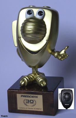 Troph&eacute;e pr&eacute;sentant un micro de CiBi avec bras et jambes mont&eacute; sur socle en bois verni